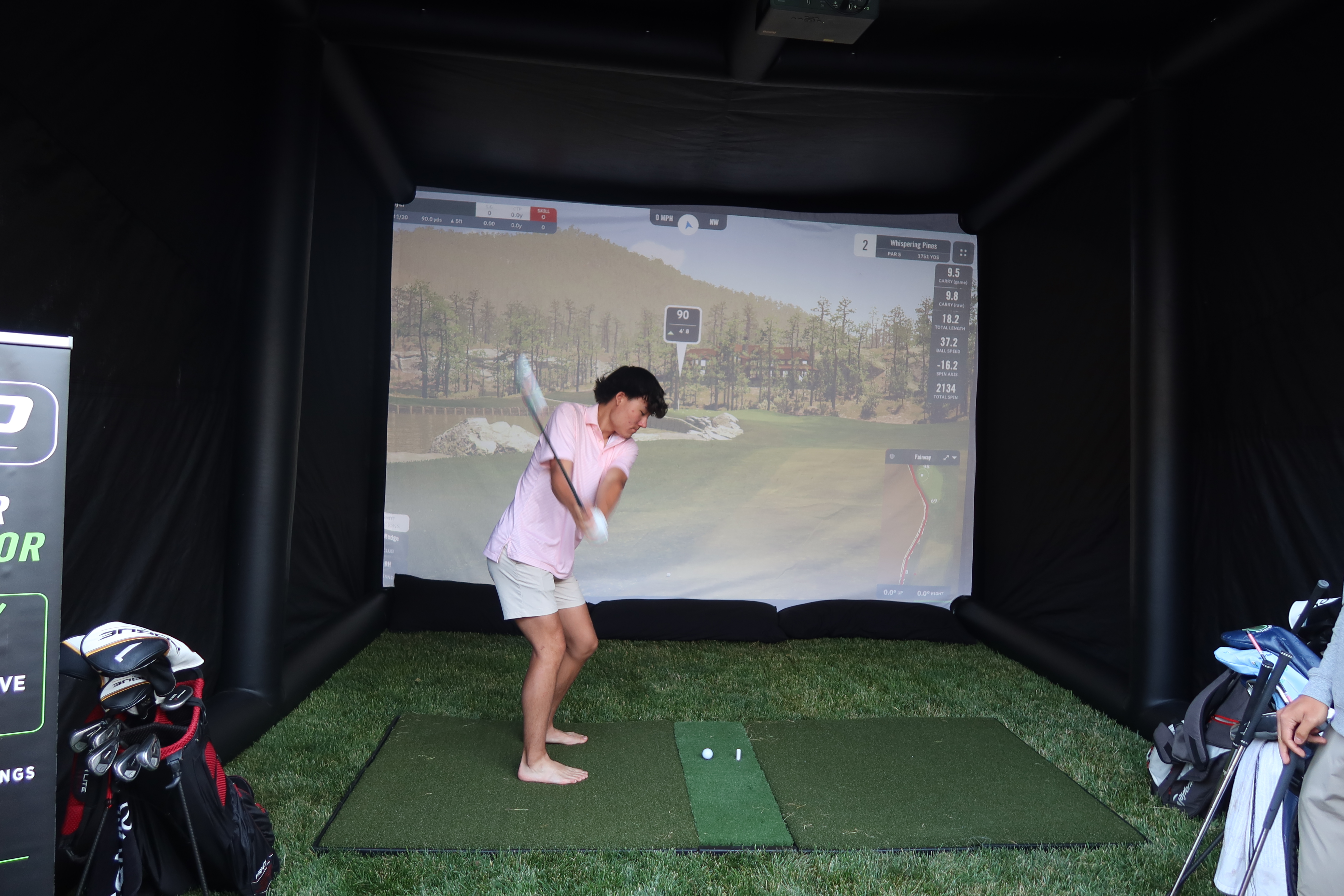 Golfer taking a swing at a Golf n Go indoor simulator event