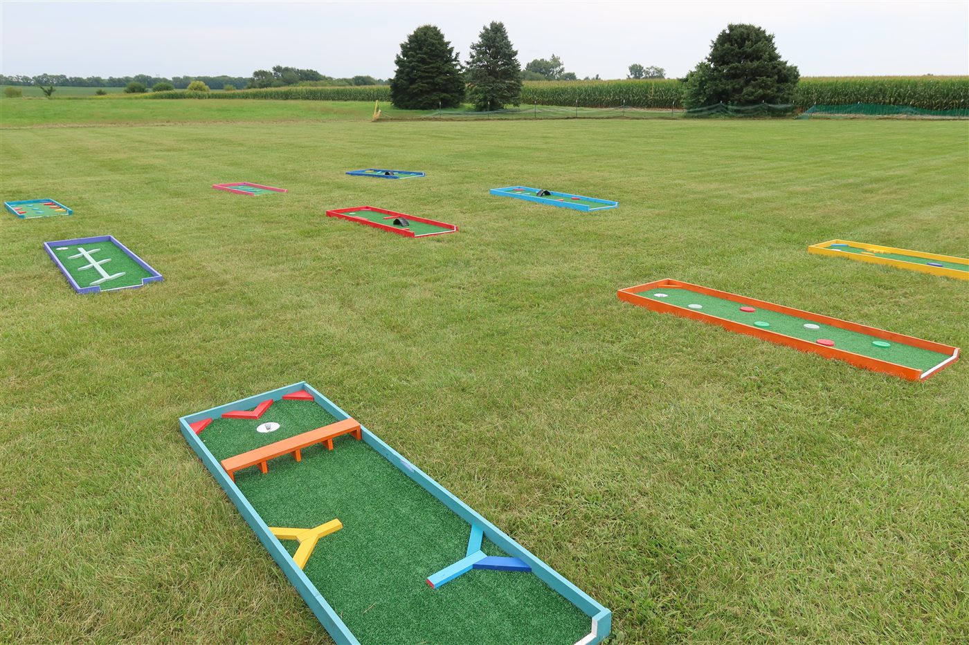 Nine-hole mobile mini golf course setup with obstacle features